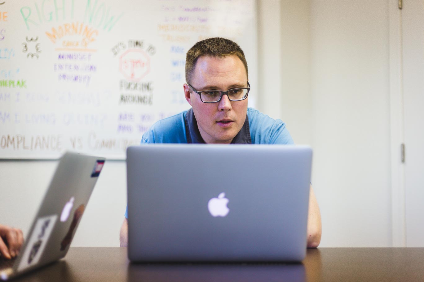 fred-weaver-looking-at-macbook-during-work-meeting-for-real-estate-photographer-session-in-tempe-az-by-prefocus-solutions-branding