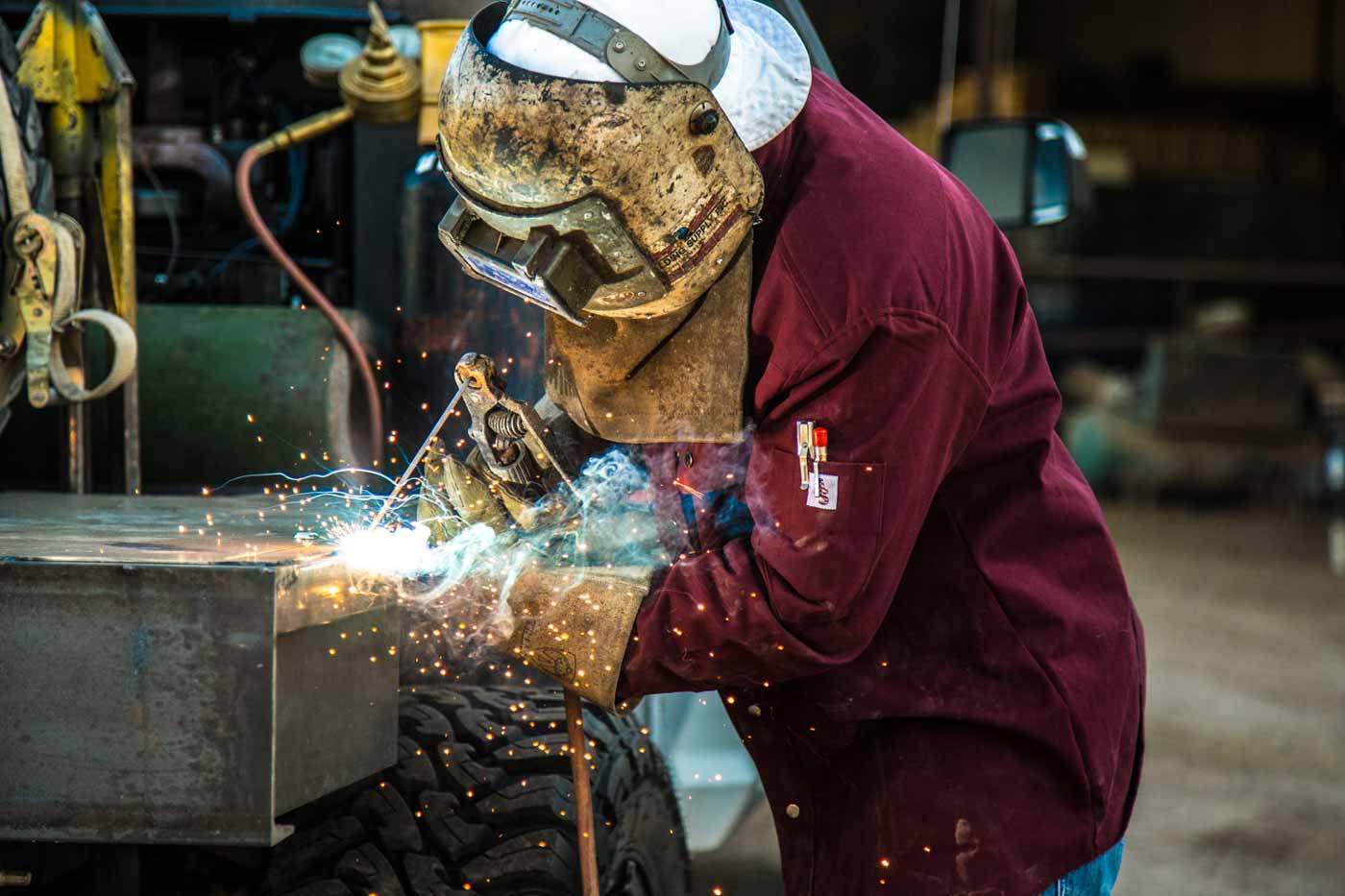 man wearing metal hood blue flame molding weld for customer in desoto county mississippi american apparel product shoot by prefocus solutions