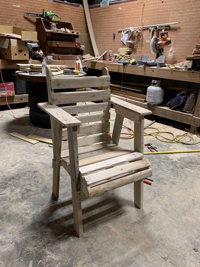 work shop in background with saws with custom woodwork chair situated for display by north mississippi craftsman jordan trask taking custom orders for kitchen furniture and home or office decor