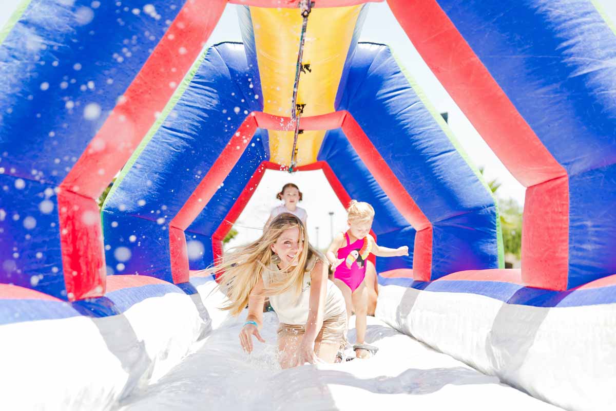 woman crawling down blow up water slide tunnel during employee partner event near memphis tennessee for updated website imagery to improve seo and local reach with prefocus solutions