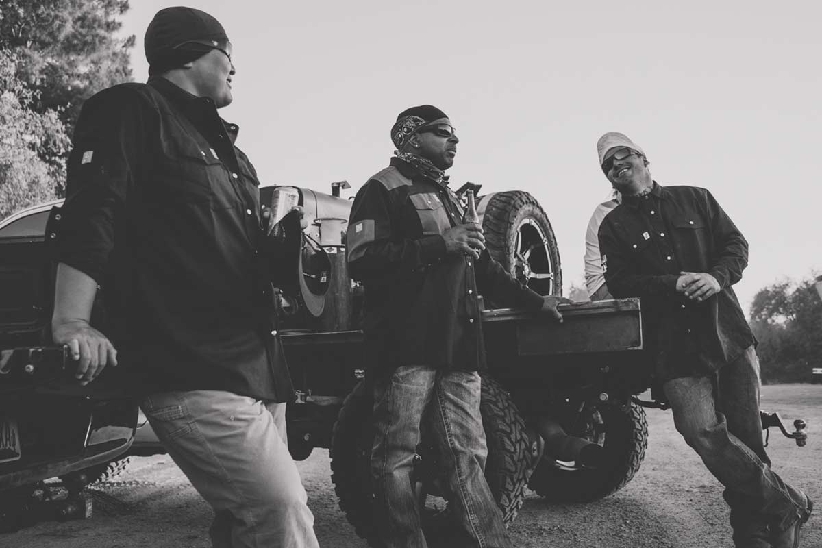 co workers of quality mechanic culture standing outside after a long day in branded attire back of truck black and white edit from low angle by prefocus solutions to update about content website pictures to garner more traffic and customer awareness memphis tn