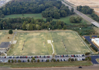 looking down on george harrison recreational facilities in desoto county ms 3 fields new buildings and youth league games ongoing at night before sundown stadium lights on 2022 prefocus drone
