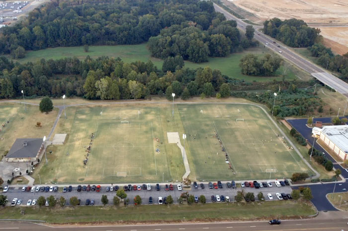 looking down on george harrison recreational facilities in desoto county ms 3 fields new buildings and youth league games ongoing at night before sundown stadium lights on 2022 prefocus drone