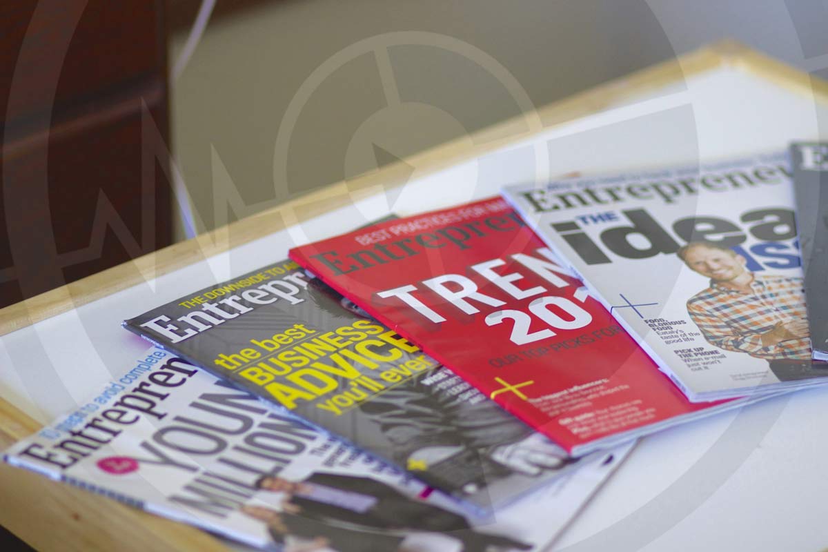 different prominent magazines that cost a lot of money to advertise in spread out on white table at office for ideal customers but aren't only means of offline ad development strategies