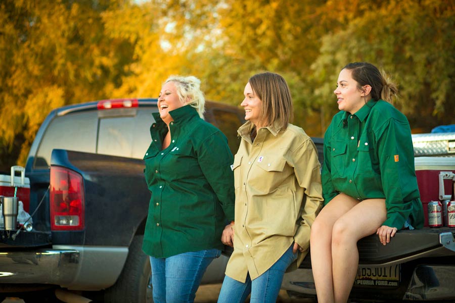 wives of blue collar workers enjoying american made apparel seated on back of work trucks laughing during sunset midsouth autumn creative strategist prefocus solutions near memphis tn