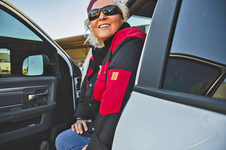 woman in sunglasses as sun sets sitting in drivers seat of chevy truck in quality workwear for photoshoot with creative director jordan trask of prefocus soluitions on location strategies for website branding near memphis tenn