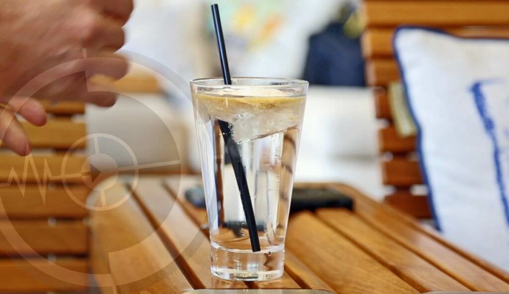 close up shot of a glass with water in it at eatery with drink powder added and stired for b-roll affect during video shoot by prefocus solutions near memphis tn