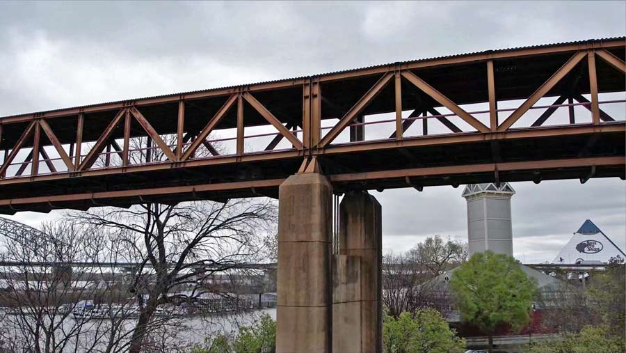 steel iron pedestrian walk bridge at tennessee welcome center connecting across wolf river lagoon to river museum near uptown memphis captured by drone pilot prefocus solutions