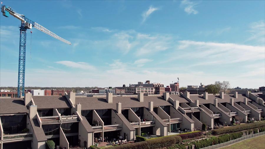 construction crane blue skies behind mississippi river park residencies with green front lawns in facelift area of uptown memphis caught by drone pilot camera prefocus solutions real estate photographer